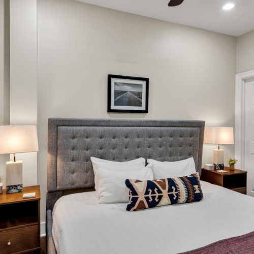 Gray tufted bed with curated gallery art