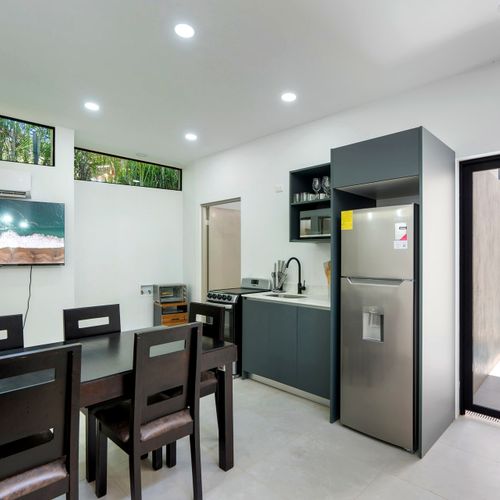 Open kitchen and dining area with glass door to private plunge pool at Casa Margarita, Tamarindo.