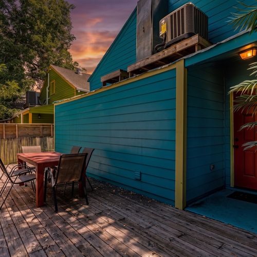 Colorful turquoise exterior w/ a private outdoor seating area — a charming spot to sip & unwind.