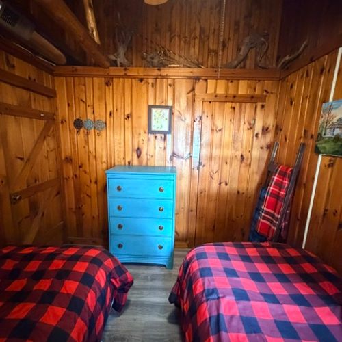 BEDROOM #3:  Features two single beds, a nightstand with a lamp, ceiling fan, and a dresser.