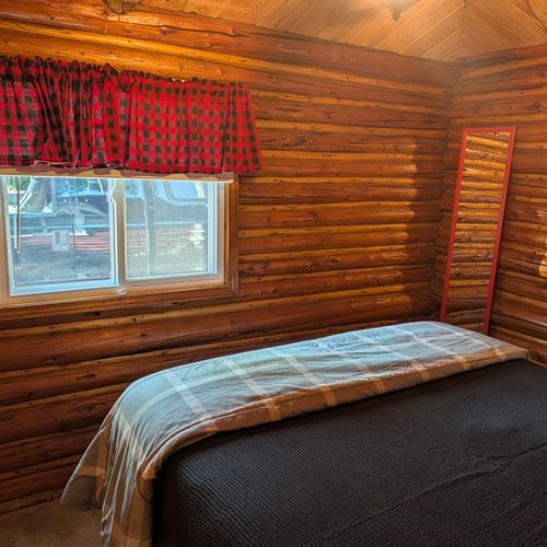 BEDROOM #1:  Features a queen-size bed, nightstand, clothes rack, and luggage stand.