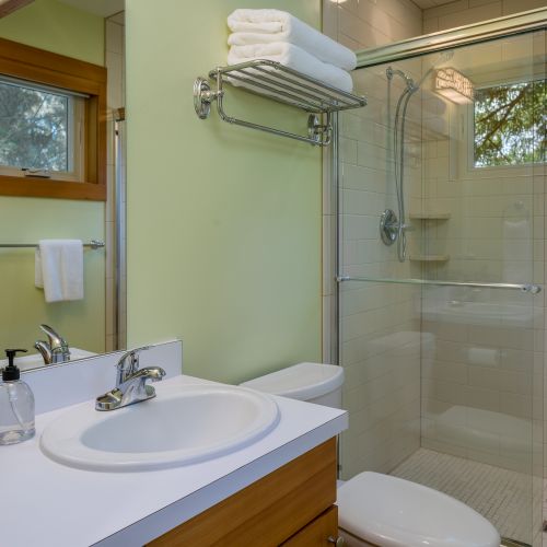 Refresh in this bright, modern bathroom featuring a spacious glass walk-in shower, fresh towels, and all the essentials for a comfortable stay.