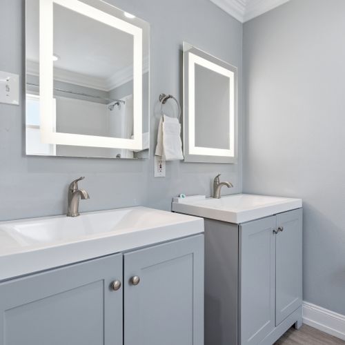 Unit 201 bathroom w/ sleek vanity, lit mirror & a fresh modern finish.