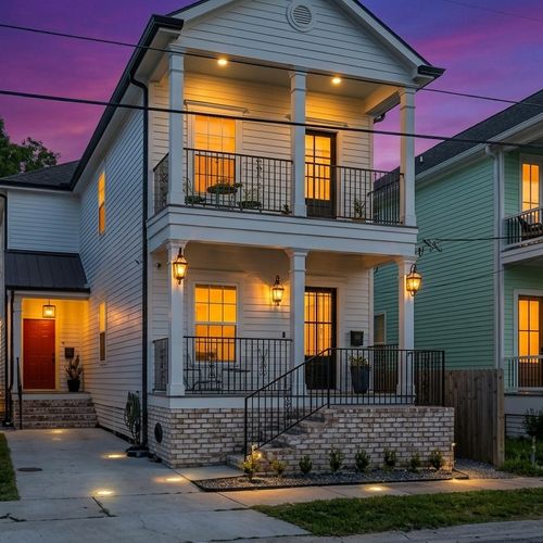Modern two-story home w/ welcoming balconies & elegant curb appeal.