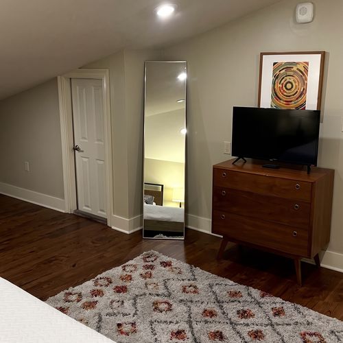 Bedroom with TV and hardwood floors