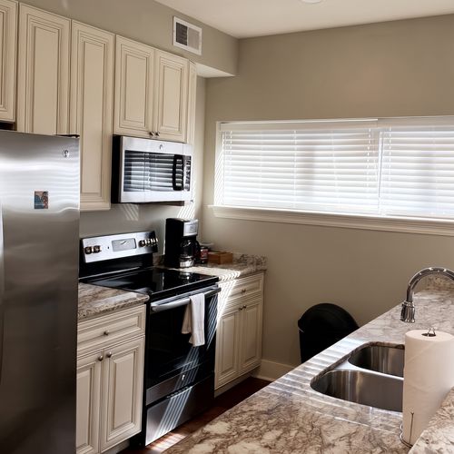 Open kitchen w/ granite island seating & pendant lighting