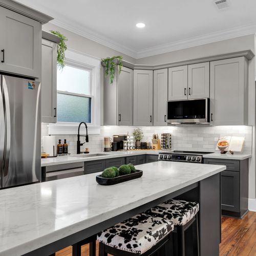Whip up meals in the sleek kitchen w/ stainless appliances, gray cabinets & a crisp white island