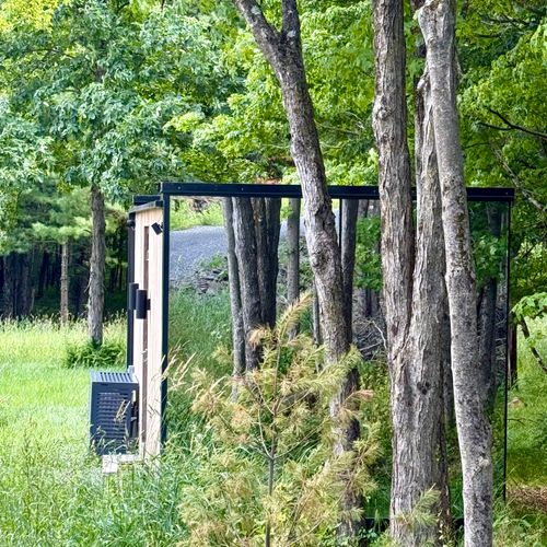 The mirrored guest house nestled quietly among the summer trees.