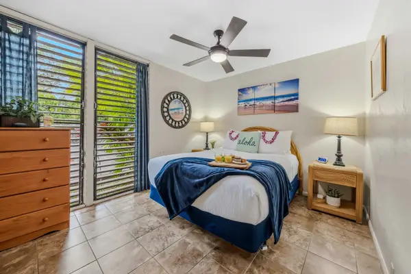 Bright bedroom featuring tropical décor and generous storage.