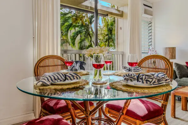 Elegant glass-top dining table with comfortable woven chairs and lush garden views. 🍽️🌿