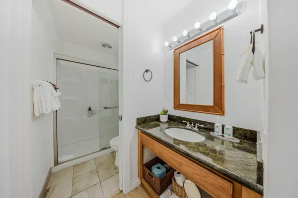 Modern bathroom featuring a sleek vanity, red-framed mirror, and walk-in shower. 🚿✨