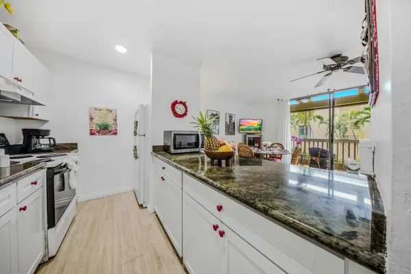 Spacious galley kitchen featuring extensive dark countertops and modern white cabinetry. 🍳✨