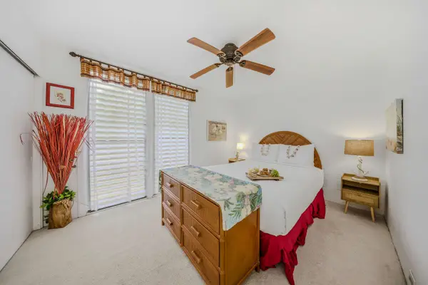 Comfortable bedroom featuring a large wood-frame bed, ceiling fan, and spacious mirrored closet. 🛌✨