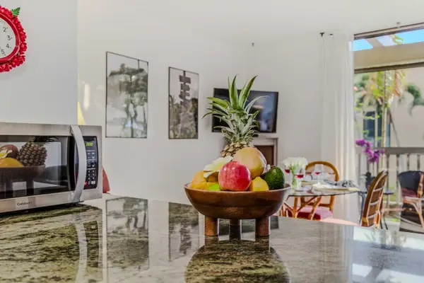 Polished kitchen countertop featuring a tropical fruit bowl, leading into the dining space. 🍍✨