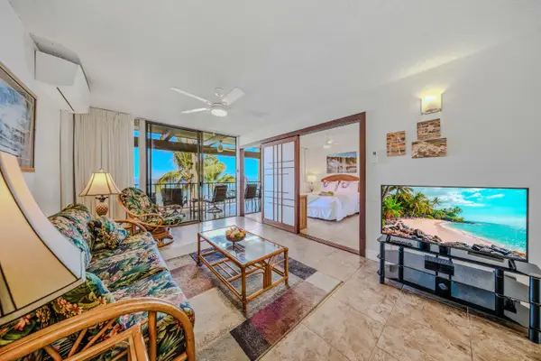 Spacious living area with comfortable seating, tropical accents, and direct balcony access. 🛋️