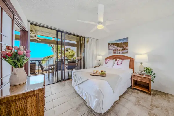 Bright bedroom layout featuring a comfortable bed, ceiling fan, and direct balcony access. 🛏️