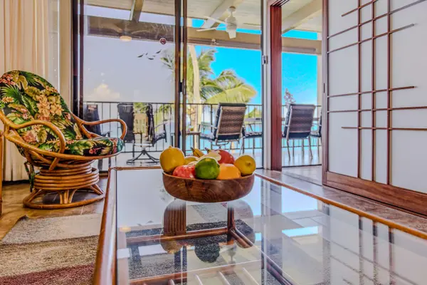 Bright living room layout featuring a glass coffee table with a fresh fruit bowl display. 🍊