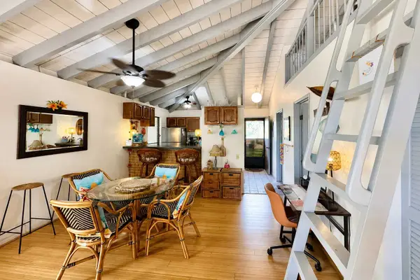 Open living room blends dining, seating, artwork, and island-inspired interiors