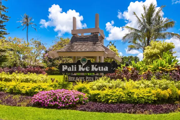 Entrance sign surrounded by tropical landscaping