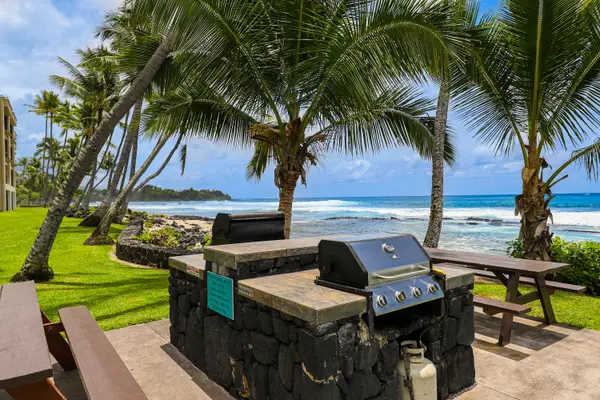 Oceanfront Outdoor BBQ Grill Station with Picnic Tables and Palm Trees