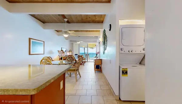 In-Unit Stacked Washer and Dryer Setup with Open View to Dining Area