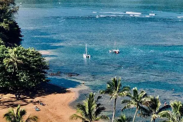 Coastal waters sparkle beneath blue skies, boats, and island scenery