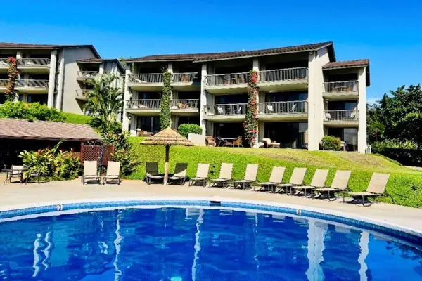 Resort pool shimmers beside sun loungers and flourishing island gardens