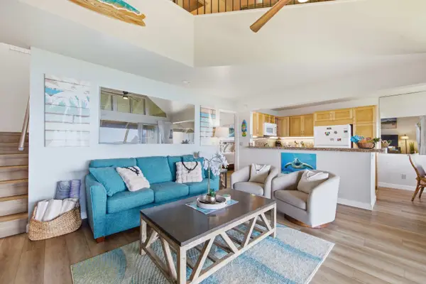 Coastal living room showcases decorative accents, soft seating, and bright views