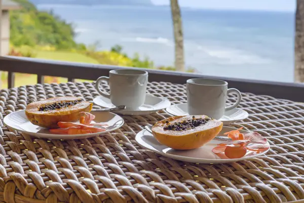 Breakfast on the lanai features fresh fruit, coffee, and beautiful coastal views