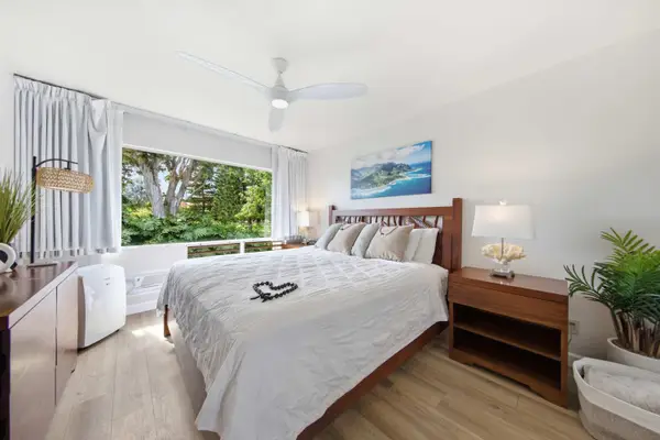 Restful bedroom features layered bedding, calming artwork, and natural brightness