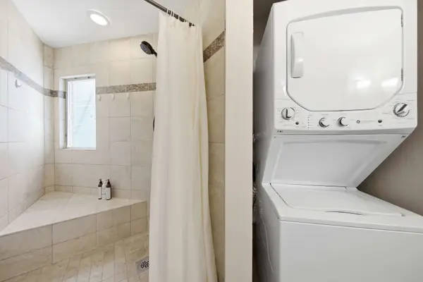 Updated bathroom offers a spacious vanity, refreshing shower, and washer & dryer.