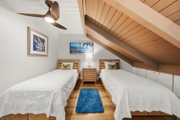 Sleeping area combines bedding, wood accents, and floral decor altogether