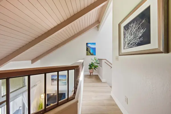 Bright hallway features vaulted ceilings and artwork.