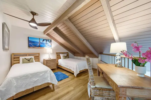 Cozy loft offers comfortable beds, a worktable, and tropical artwork
