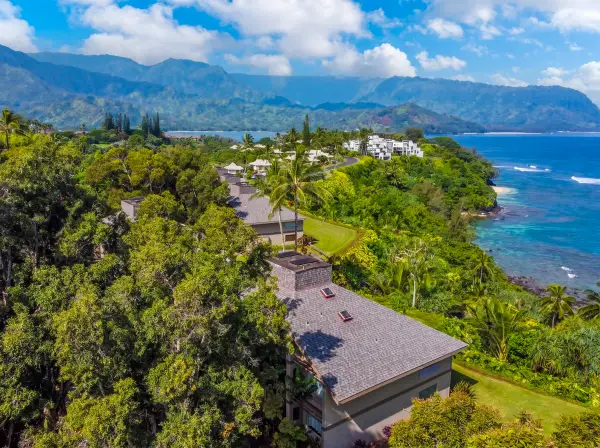 Tropical surroundings stretch toward distant hills, gardens, and open skies