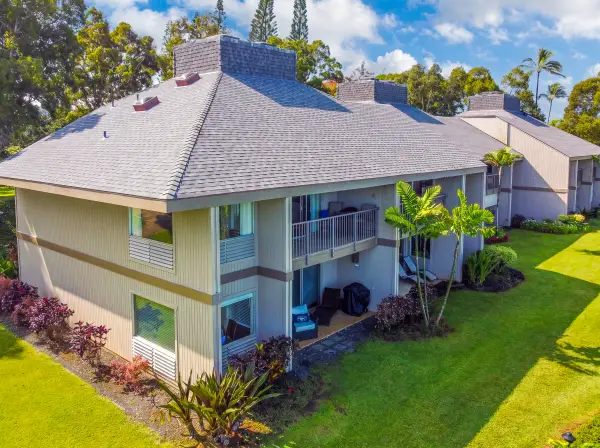 Coastal home exterior features architecture, landscaped gardens, and open lawns