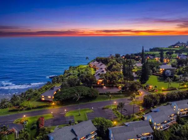 Coastal sunset creates a breathtaking backdrop above tropical homes and palms