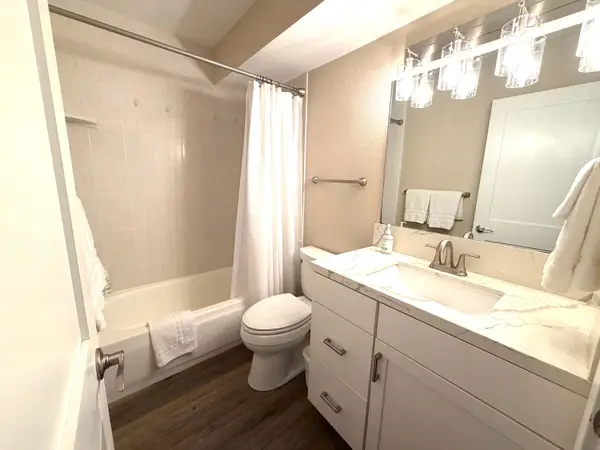 Pristine full bathroom with a spacious vanity and bright lighting