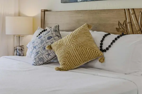 Close-up of King bed with plush pillows & wooden headboard