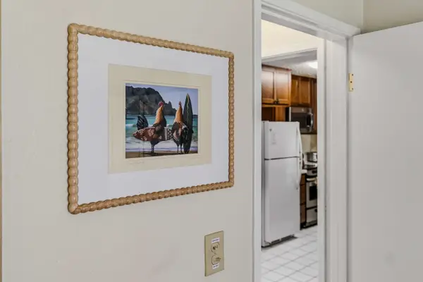 Hallway wall artwork with view looking into the kitchen