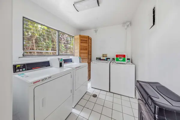 Shared laundry room with multiple washers and dryers