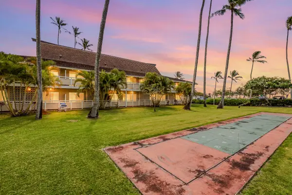 Sunset view of resort pool and lush tropical lawn