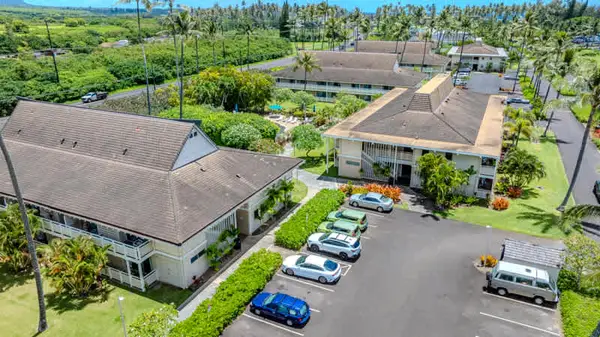 ​Aerial view of resort buildings, parking lot, and tropical grounds