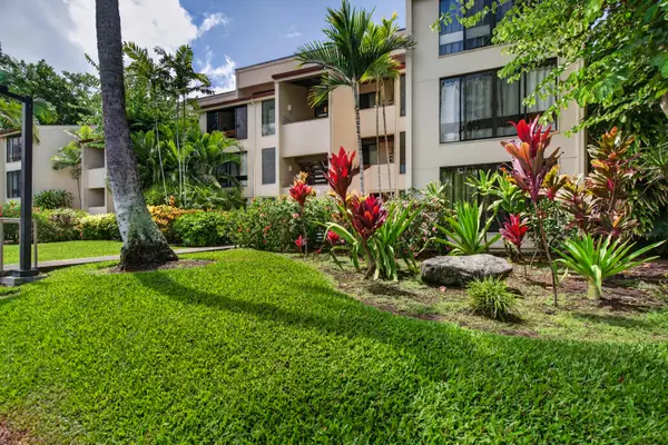 Resort exterior view with lush lawn and tropical gardens