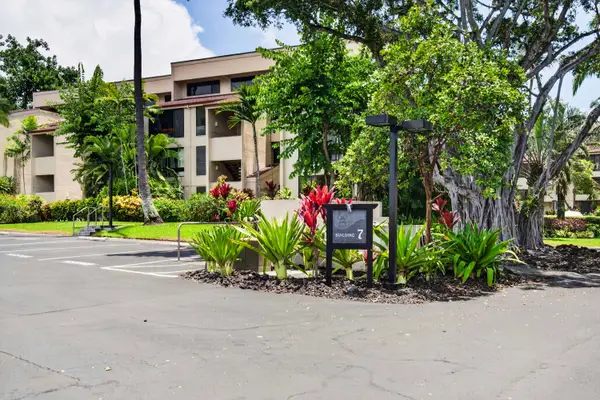 Resort exterior surrounded by lush tropical gardens and parking area