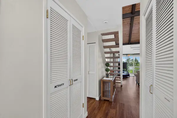 Hallway entrance with built-in storage closets and stairs leading to loft