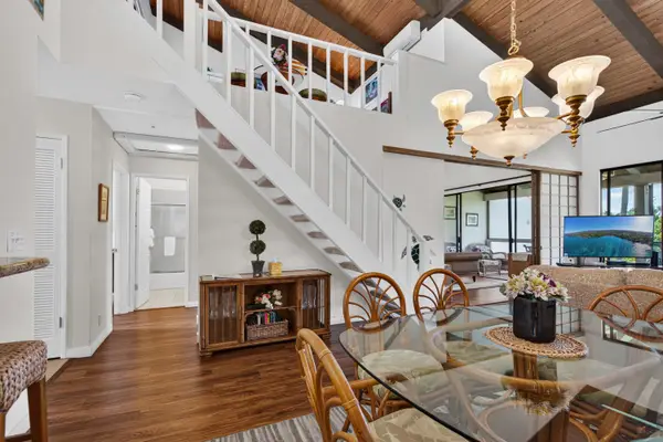Glass dining table with chandelier and staircase access
