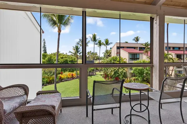 Screened balcony with comfortable seating and garden views