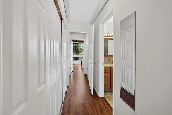 Hallway with sliding closet doors and bathroom access