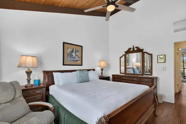 Primary bedroom featuring king bed, wooden vanity dresser, and ceiling fan